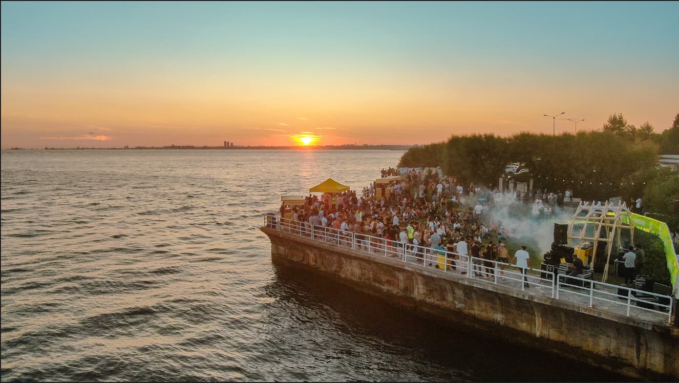 A SUNDAZE gathering beside the water at sunset