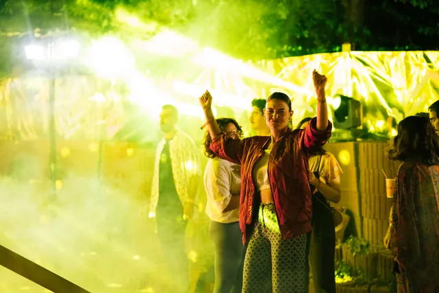 A group dancing beneath yellow lights